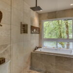 A glass wall for the shower, followed by the oversize custom jetted spa tub with led lighting. Relax your muscles while taking in the sounds of the river.