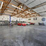 This space is HUGE. Big enough it makes the 3 cars & motorcycle look so small! Car lift and multiple new work spaces with full cabinets & benches.