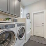 Spacious laundry room with custom cabinets and a large pet wash station!