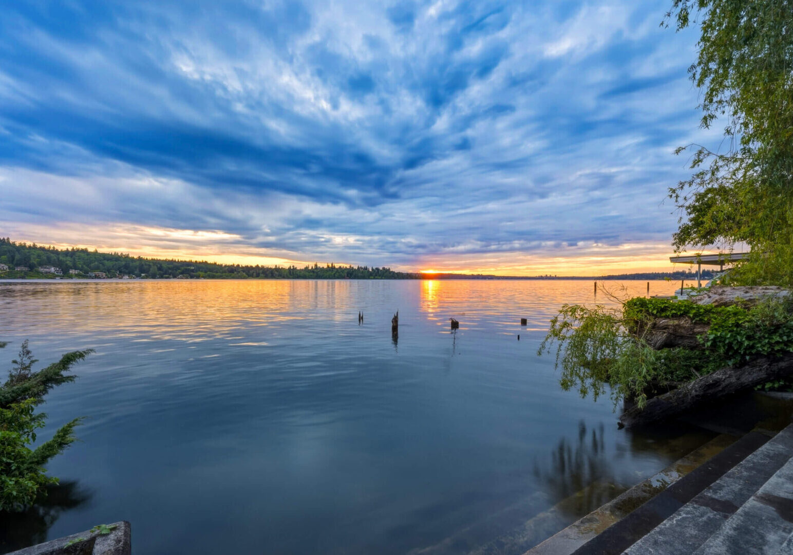 Dramatic cloudy sunset over tranquil lakeshore